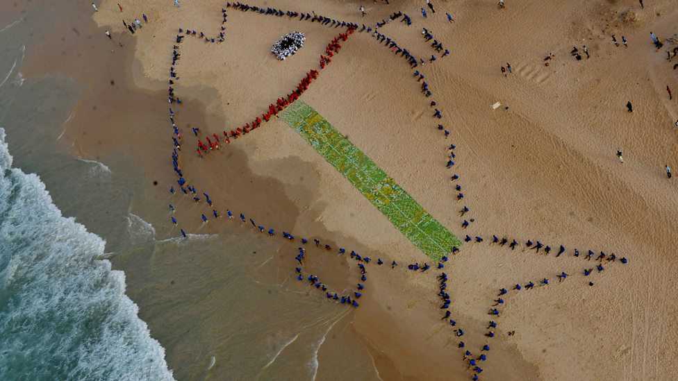 (Photo: An aerial picture shows 400 students gathering to form a giant fish on the beach of Yoff Diamalaye in Dakar to draw politicians' attention to the problems of the fisheries sector. Credit: Seyllou/AFP/Getty Images)