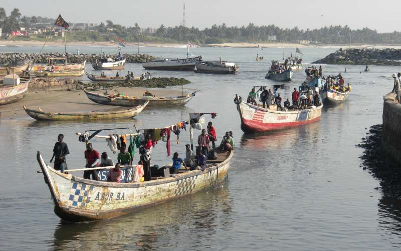 ghana - fishermen in canoe on river