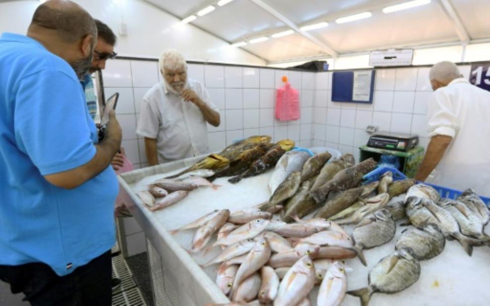 Lybia, Customers check the catch of the day at the fish market in Tripoli. By Mahmud TURKIA (AFP)