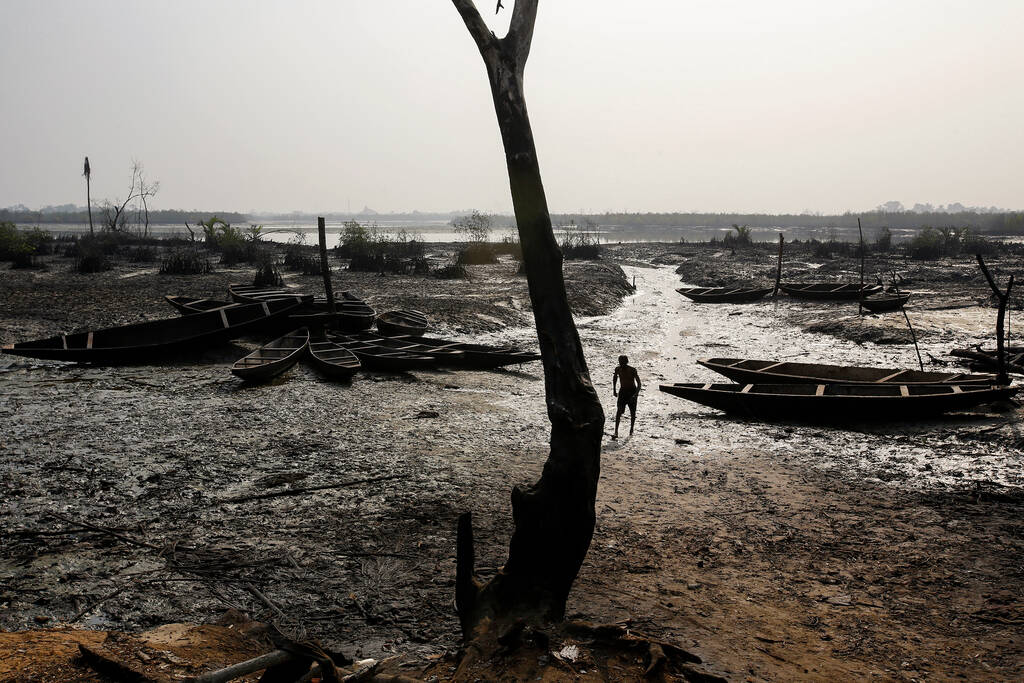Des bateaux de pêche abandonnés reposent sur le sol alors que la pollution par le pétrole brut recouvre le rivage d'un estuaire à B-Dere, Ogoni, au Nigéria, le samedi 1er Février 2020 ( Bloomberg/Bloomberg via Getty images)